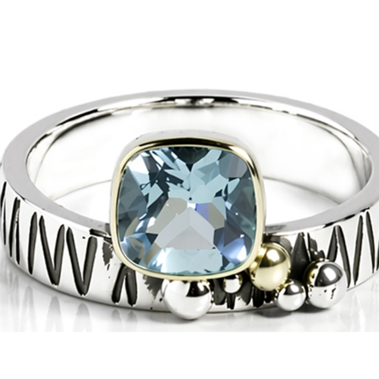 Handmade 925 sterling silver ring featuring a natural cushion-cut Blue Topaz in a bezel setting with a hand-textured band and sculptural silver bead accents.