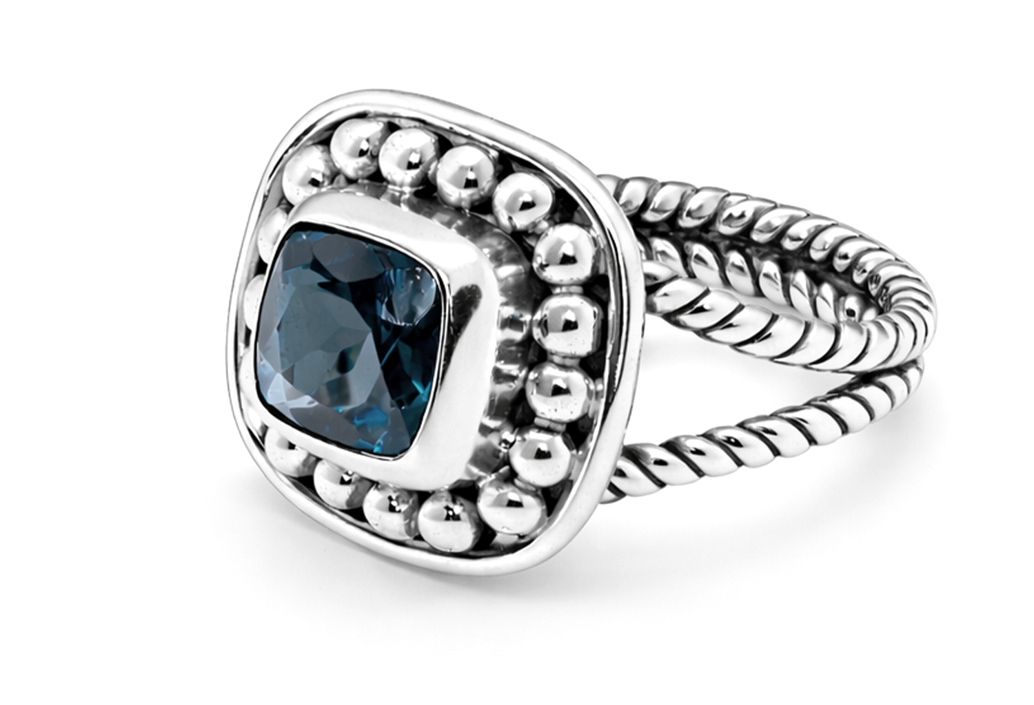 Handmade sterling silver ring featuring a genuine cushion cut London blue topaz in a polished bezel setting with a beaded halo, handcrafted braided band, and ultra mirror polished 925 sterling silver finish on a white background.
