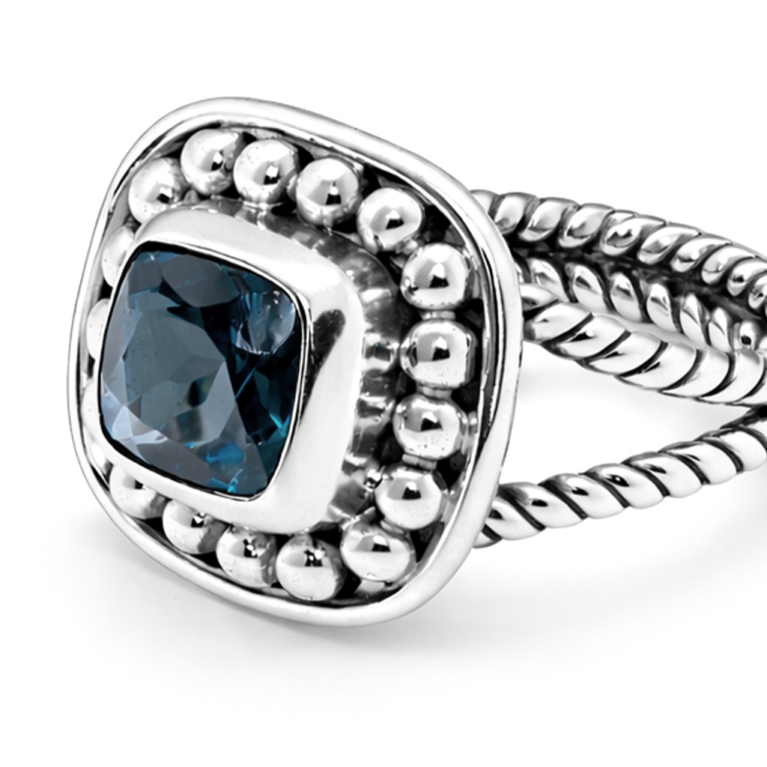 Handmade sterling silver ring featuring a genuine cushion cut London blue topaz in a polished bezel setting with a beaded halo, handcrafted braided band, and ultra mirror polished 925 sterling silver finish on a white background.