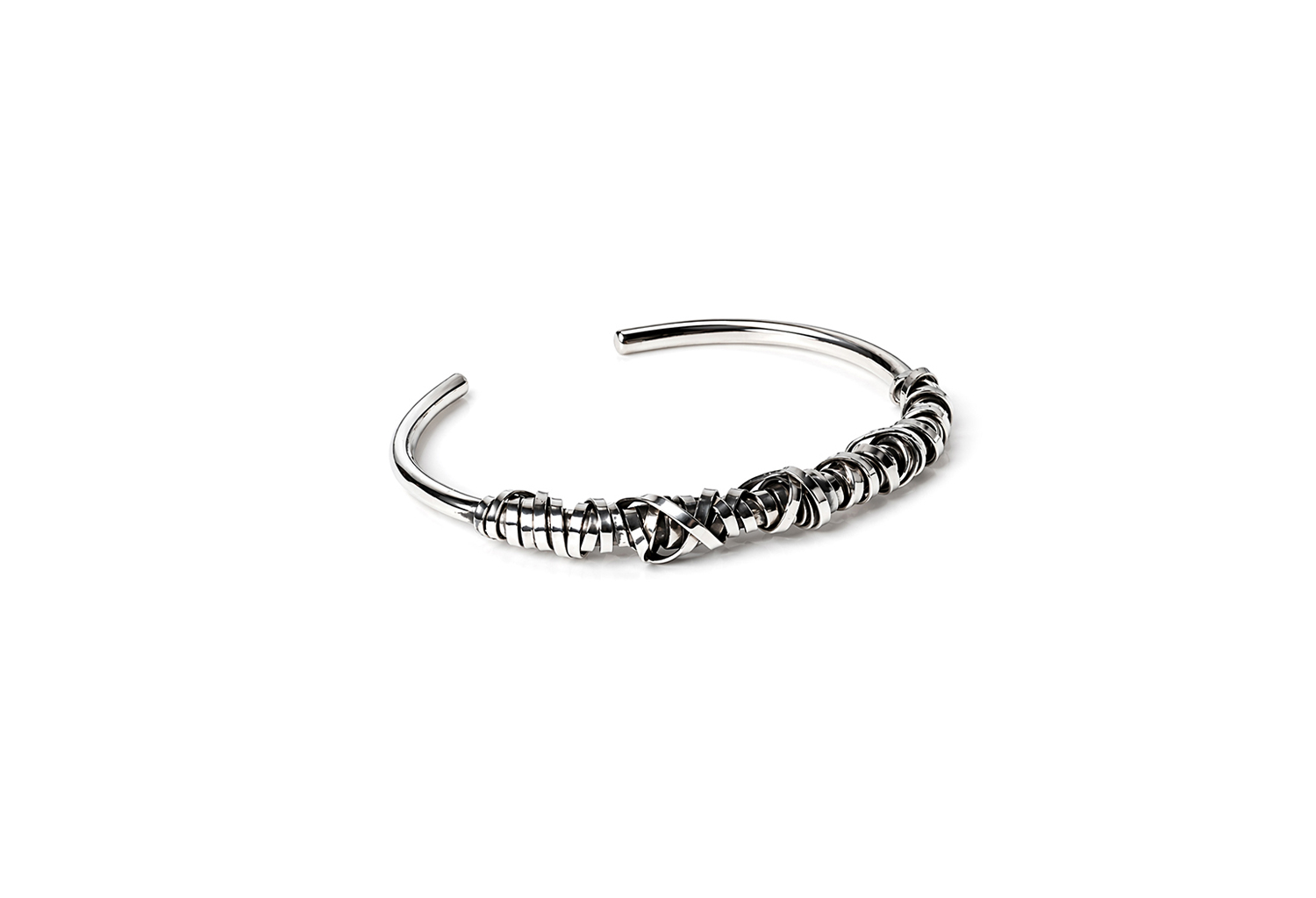 Handcrafted sterling silver wire cuff bracelet with layered sculptural design on a white background.