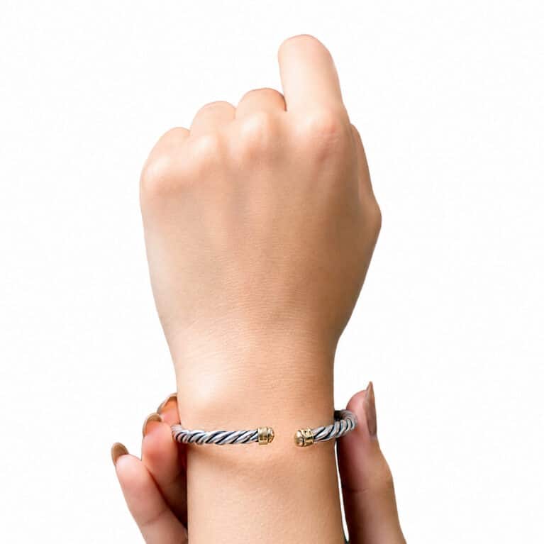Handmade twisted cable cuff bracelet in sterling silver with polished gold accents, open bangle design for women.
