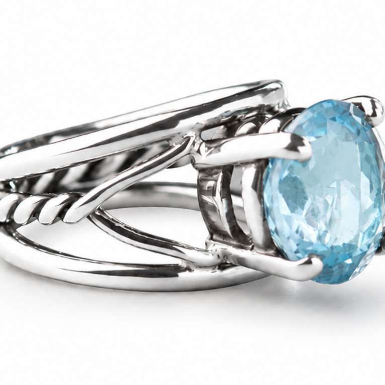 Oval blue topaz ring with a flowing split-band design in polished sterling silver.
